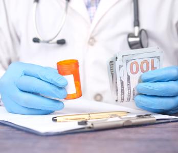 image of a physician with dollar bills in their left hand