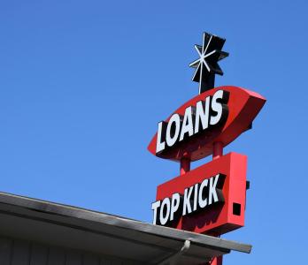 a photograph of a tall red sign which proclaims "LOANS"