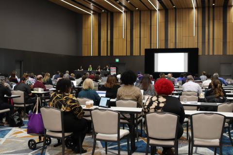 image of attendees at a conference in a paneled session