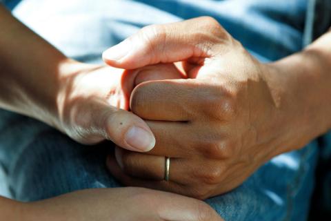 close-up photograph of two hands hold each other