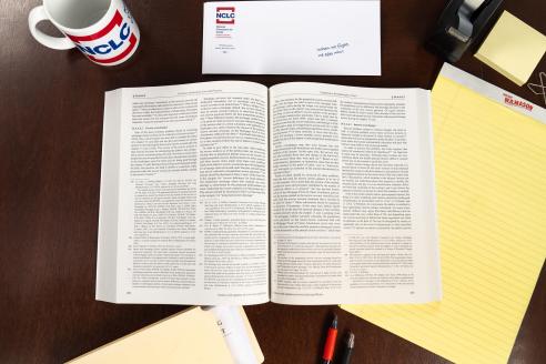 open NCLC treatise on a desk, surrounded by office supplies